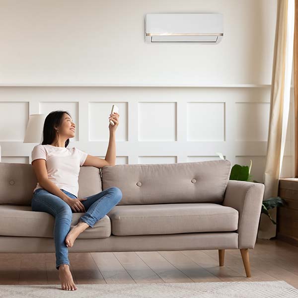 Women turning on ductless mini split A/C in her Rhode Island home